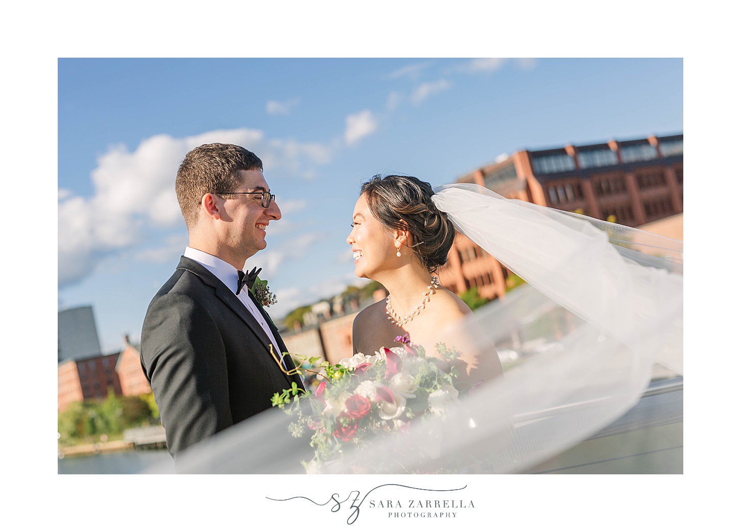 bride and groom smile with downtown Providence behind them