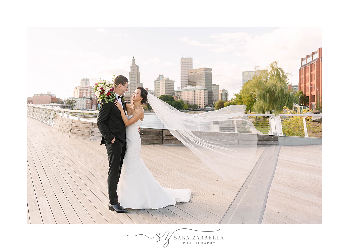 bride and groom smile while bride's veil floats behind them in Providence RI
