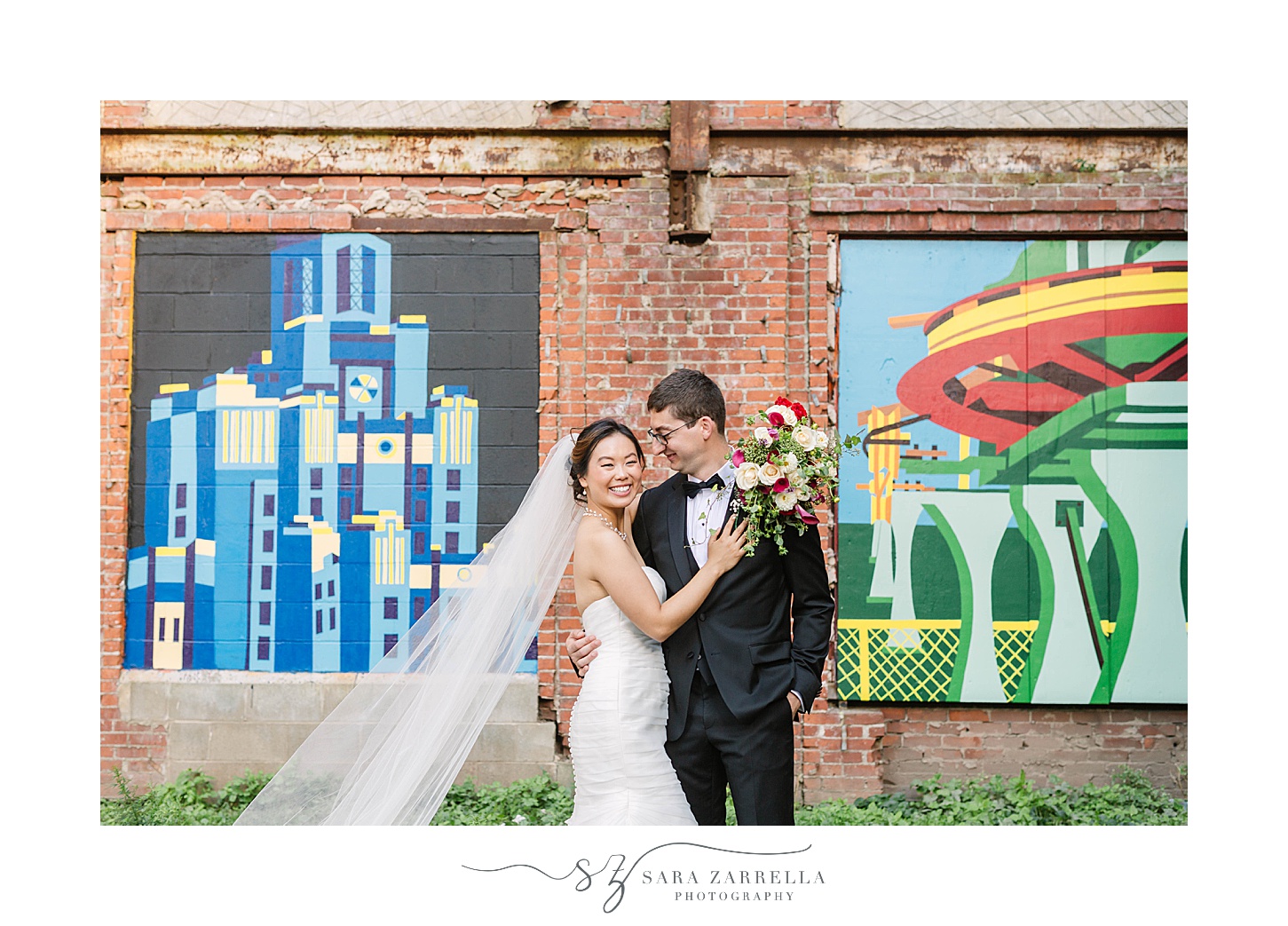 bride and groom smile by murals in Downtown Providence