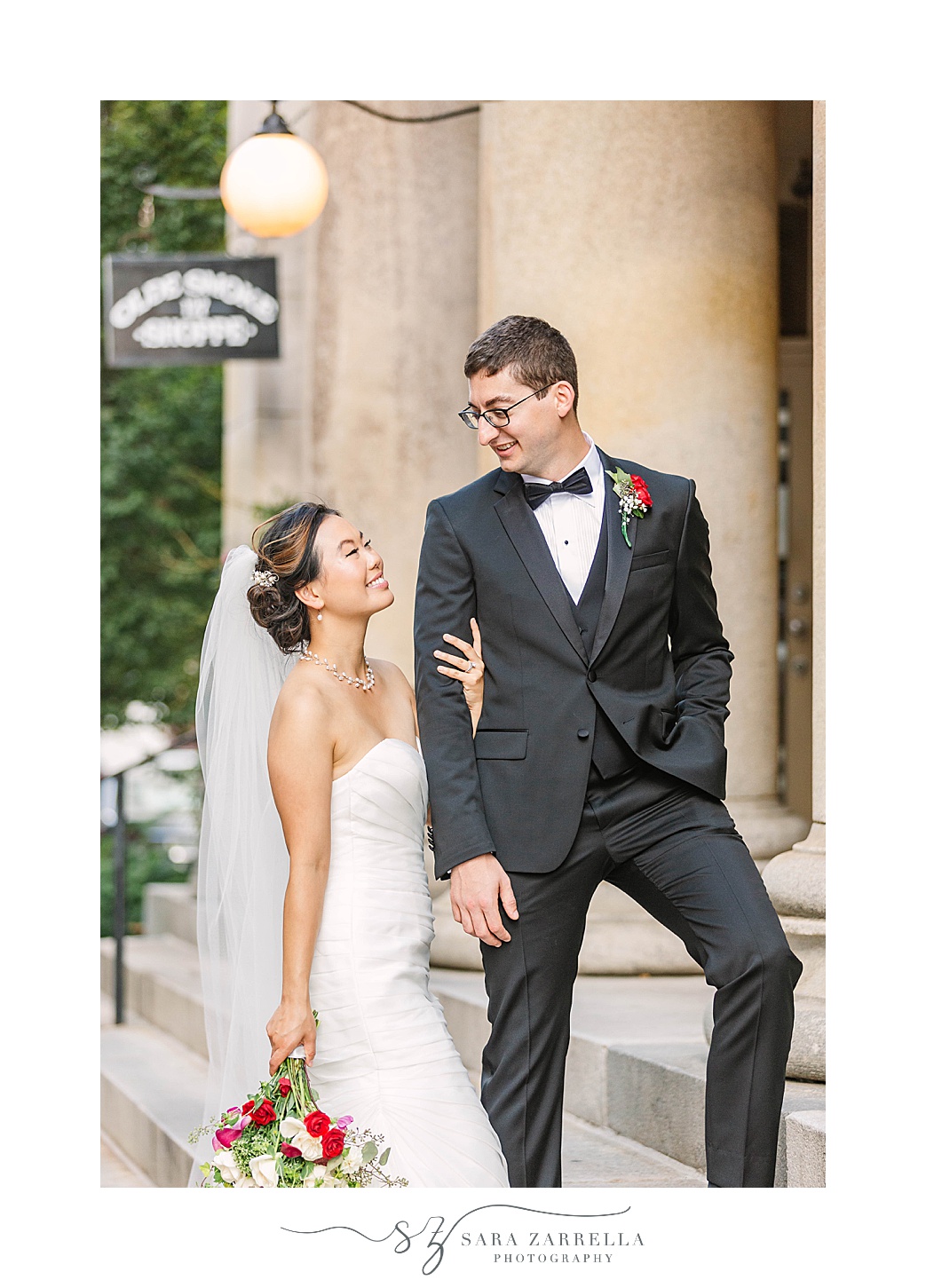 bride and groom pose on steps of building in Downtown Providence