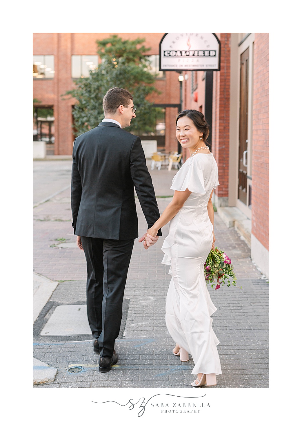 newlyweds hold hands walking down Downtown Providence street
