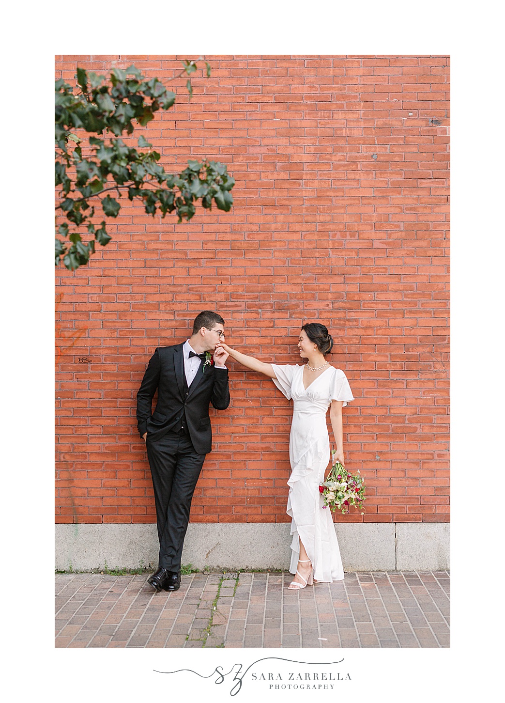 groom kisses bride's hand during Downtown Providence wedding photos