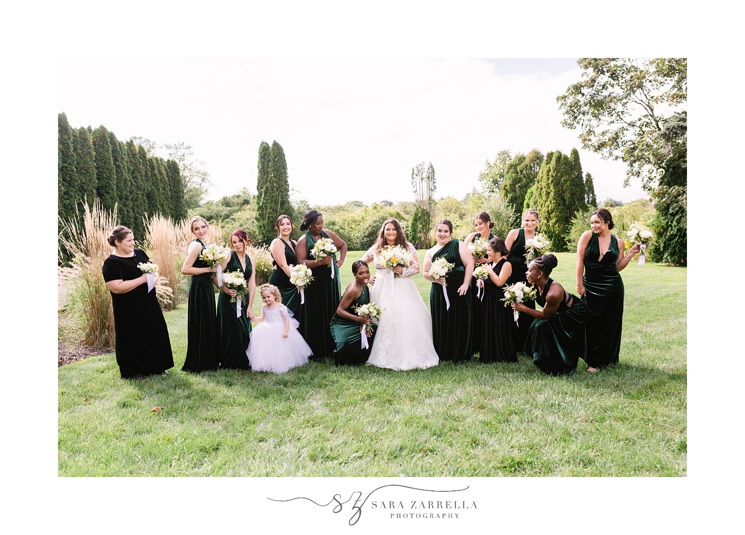 bride poses with bridesmaids in emerald velvet gowns