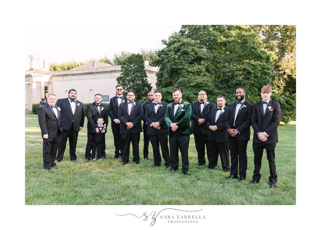 groom poses with groomsmen in black suits