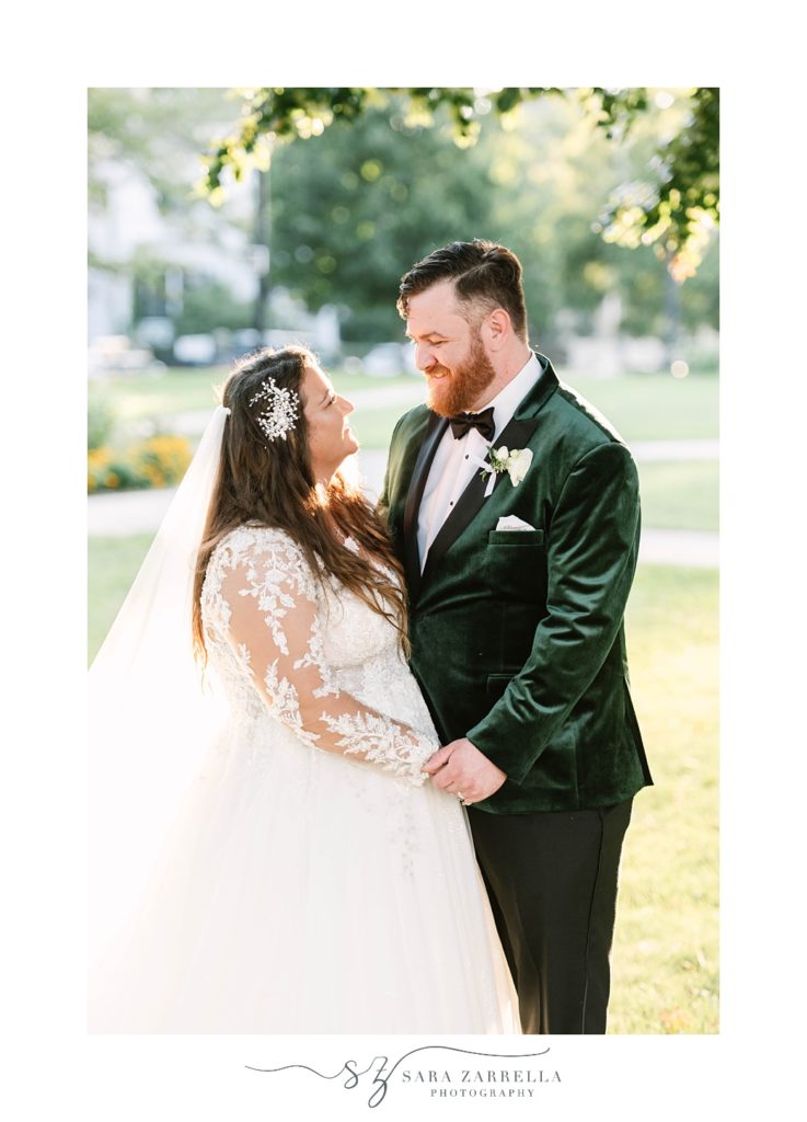 bride and groom hold hands under tree during Hotel Viking wedding portraits 
