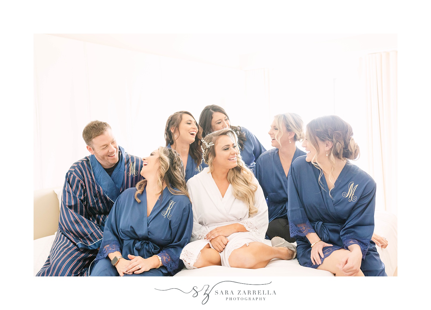 bride laughs with bridesmaids in navy robes at the Newport Navy Officers’ Club