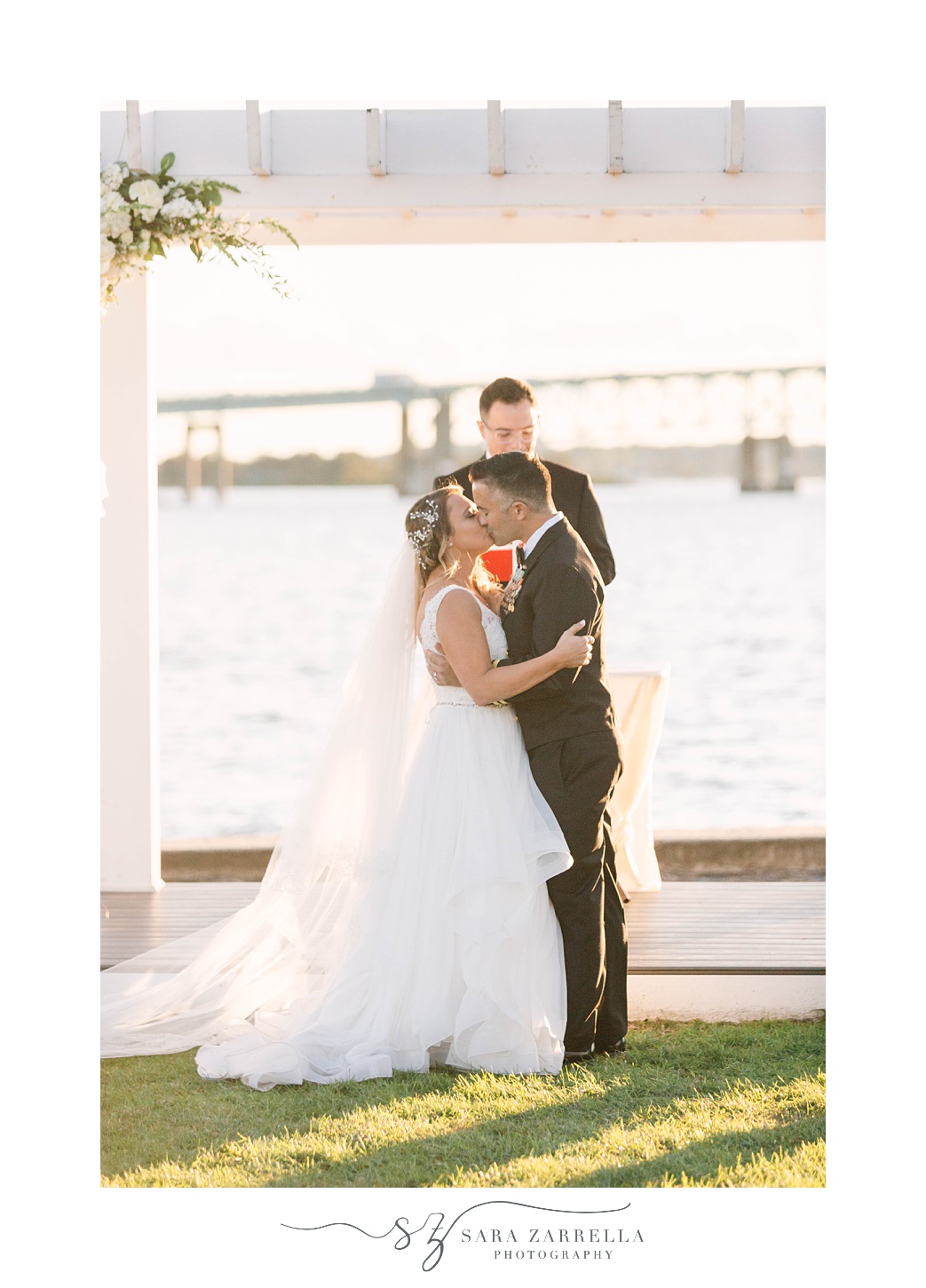 newlyweds kiss during waterfront wedding ceremony 