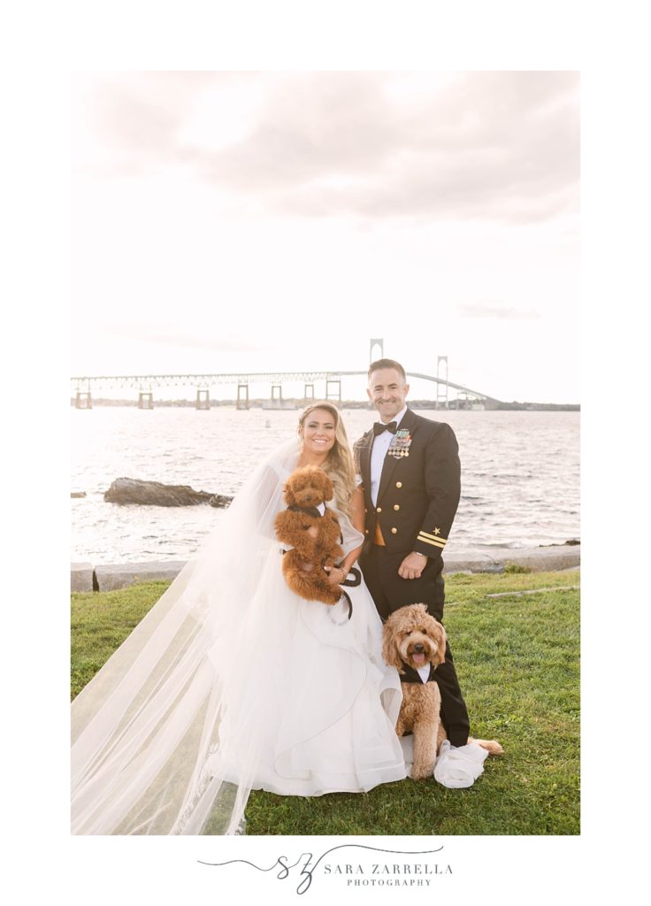 newlyweds hold dogs along water in Newport RI