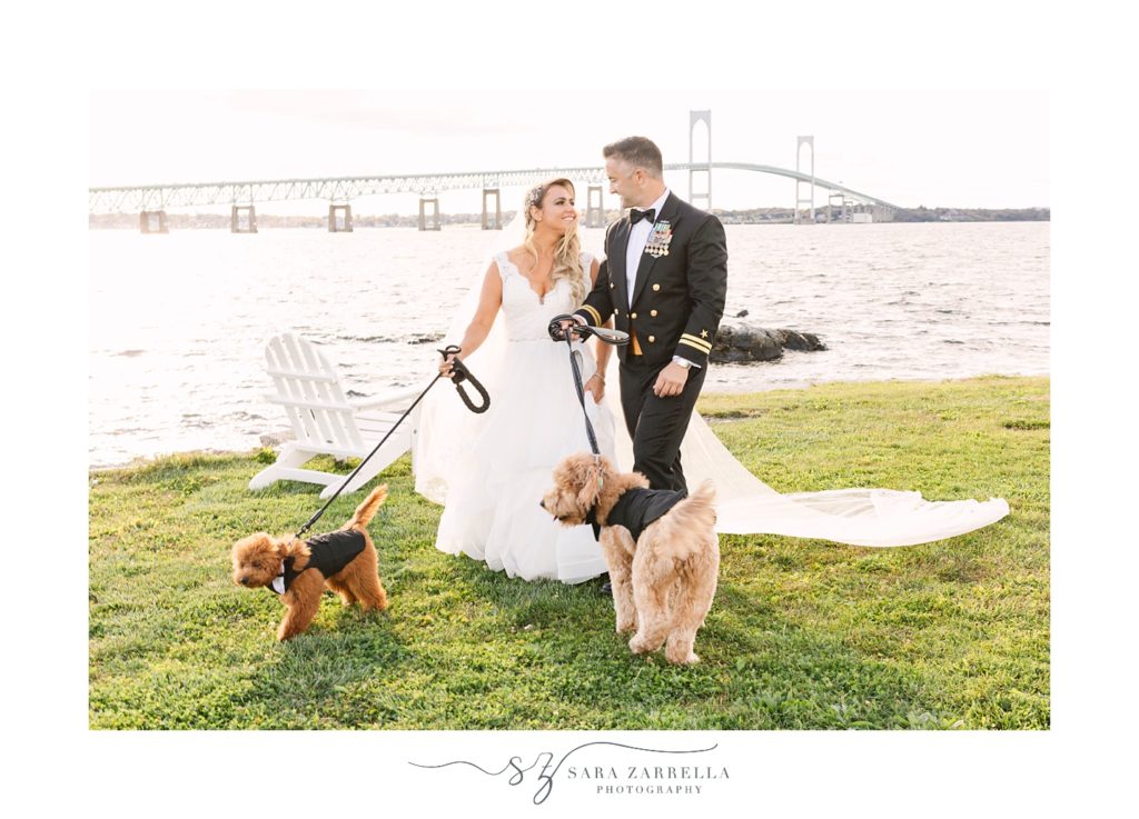 bride and groom pose with dogs along waterfront  at Newport Navy Officers’ Club