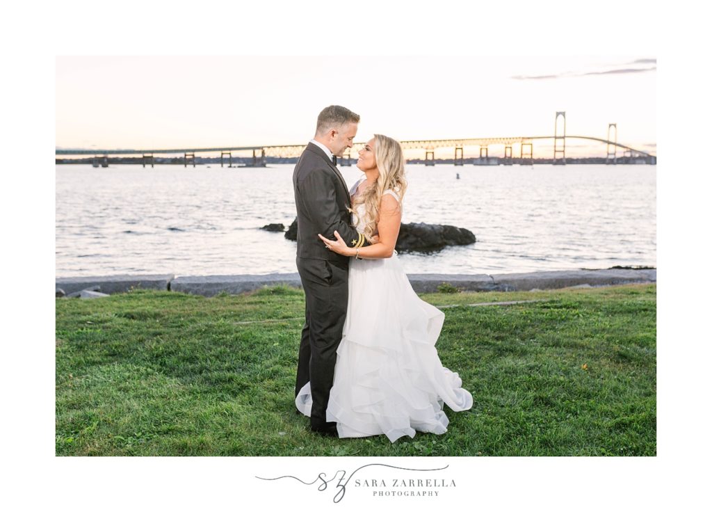 bride and groom hug along waterfront in Newport RI
