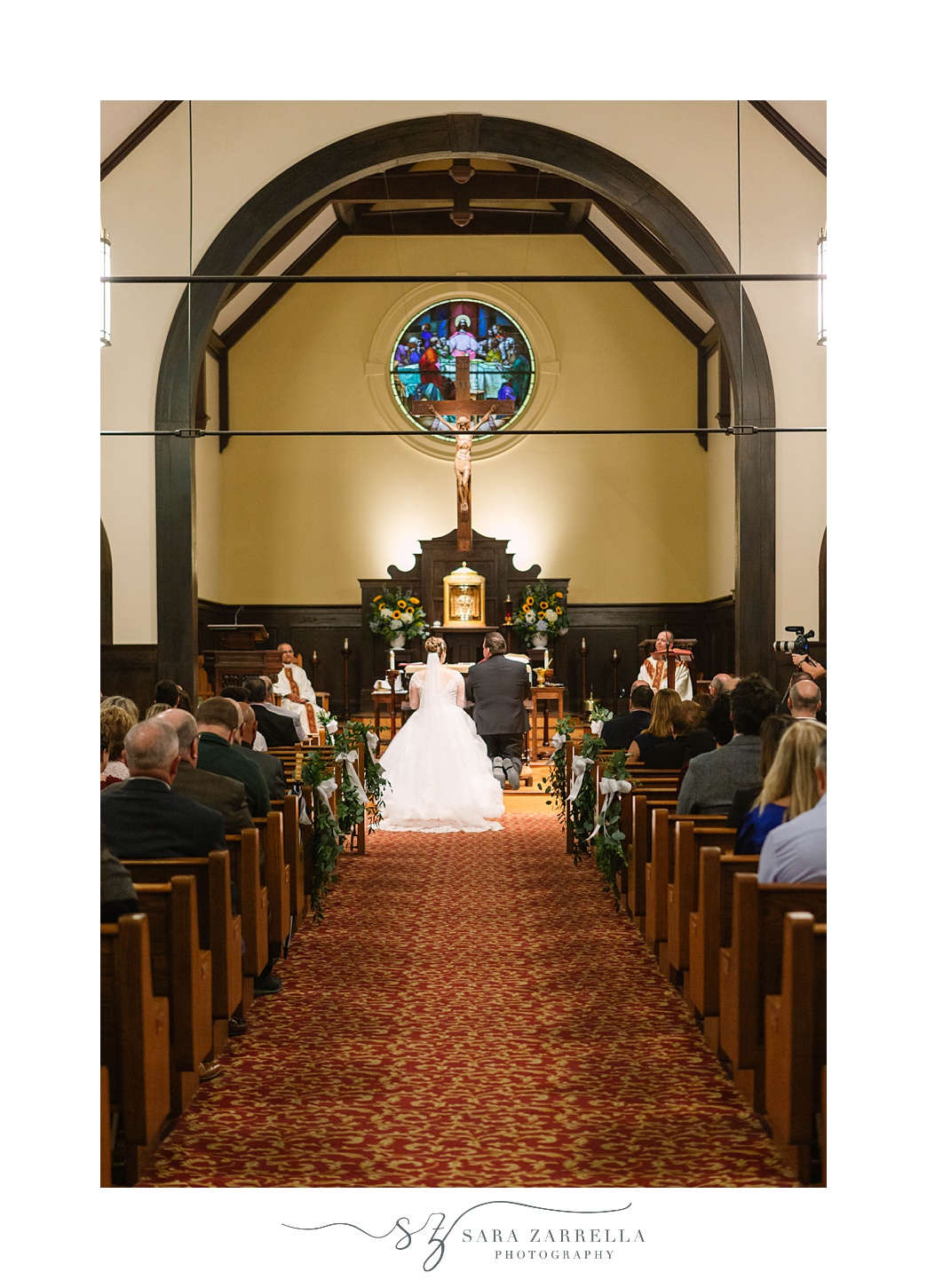 couple kneels during traditional church wedding in Rhode Island