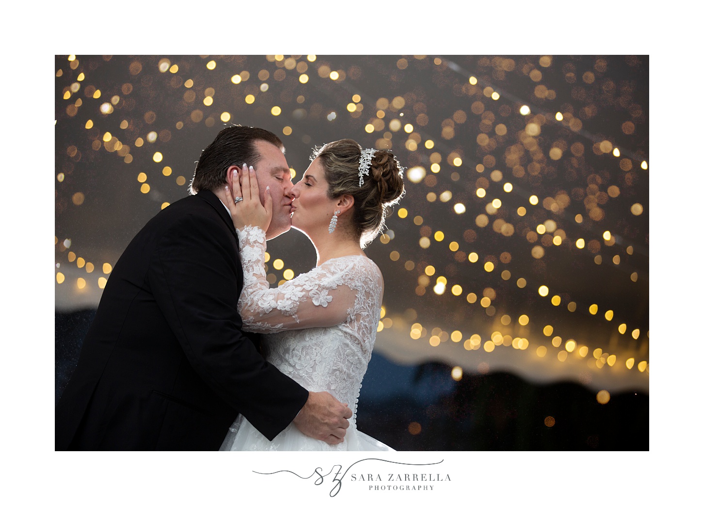 newlyweds kiss with string lights behind them at Quidnessett Country Club