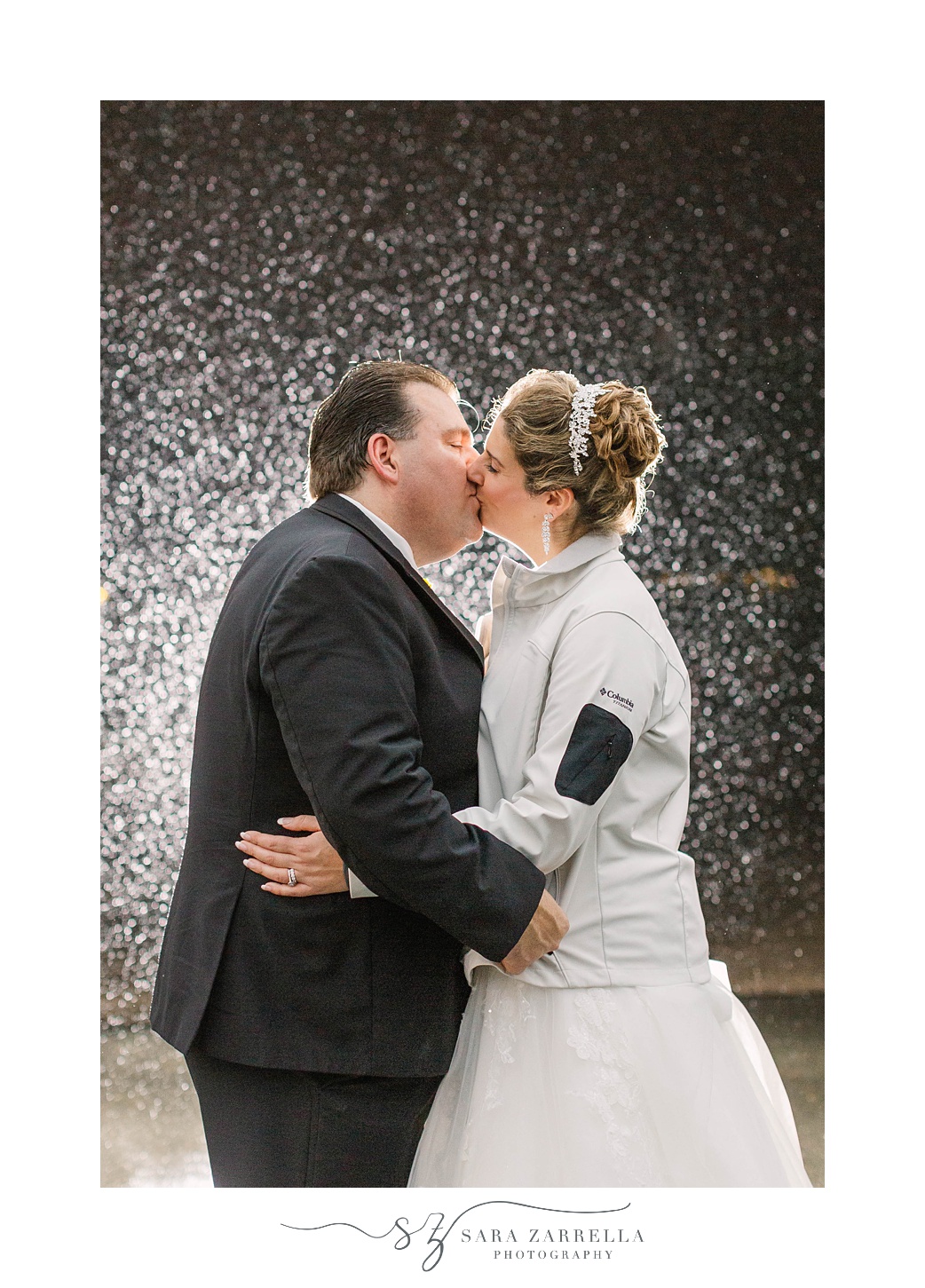 bride and groom kiss during rainy wedding day at Quidnessett Country Club