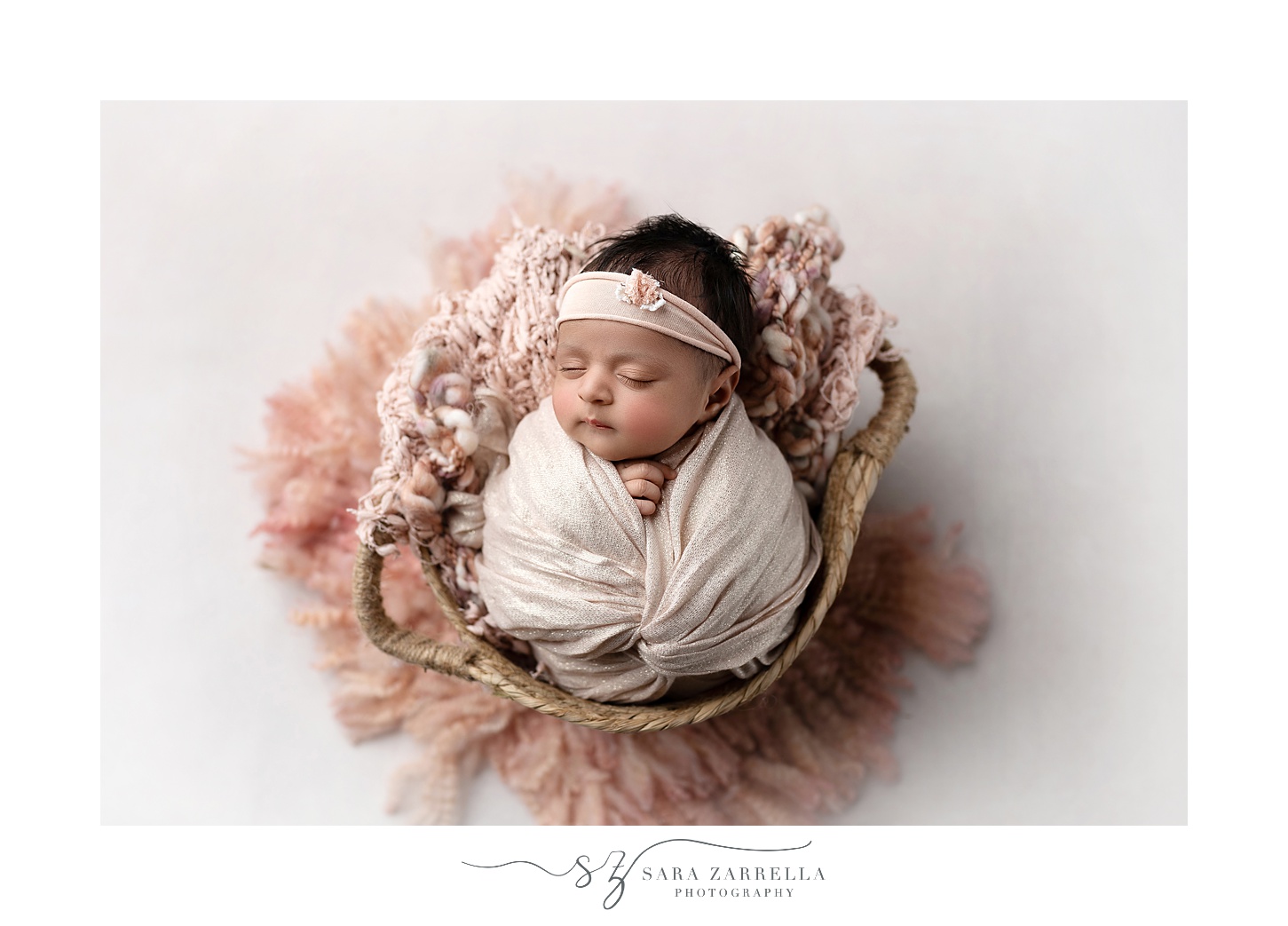 baby sleeps in basket with pink accents photographed by RI newborn photographer Sara Zarrella Photography