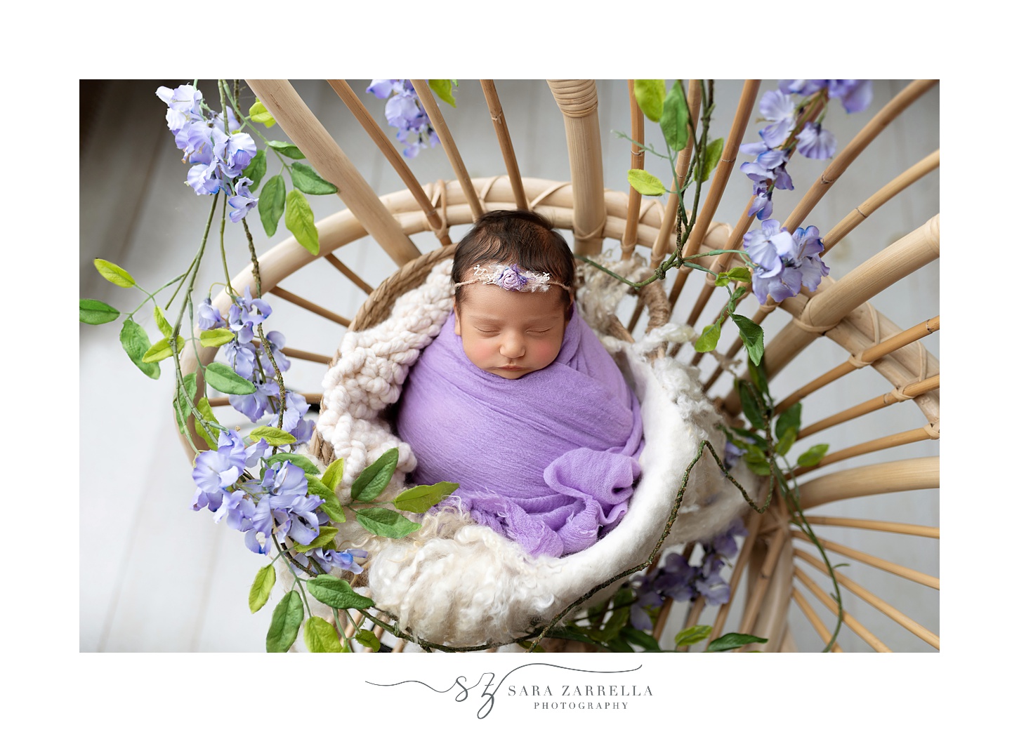 baby girl sleeps in purple wrap with floral accents 