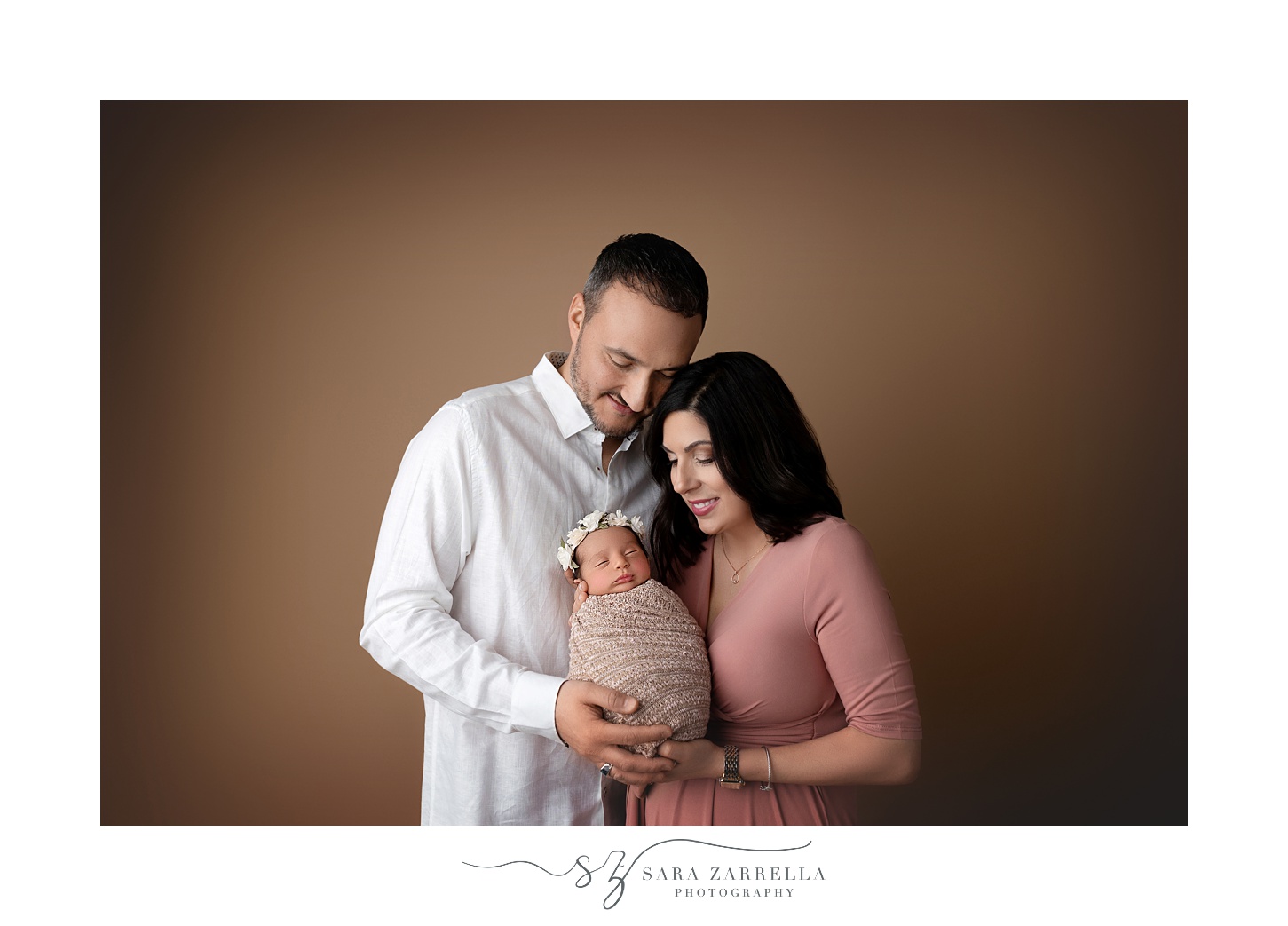 new parents hug baby girl during newborn portraits in RI studio