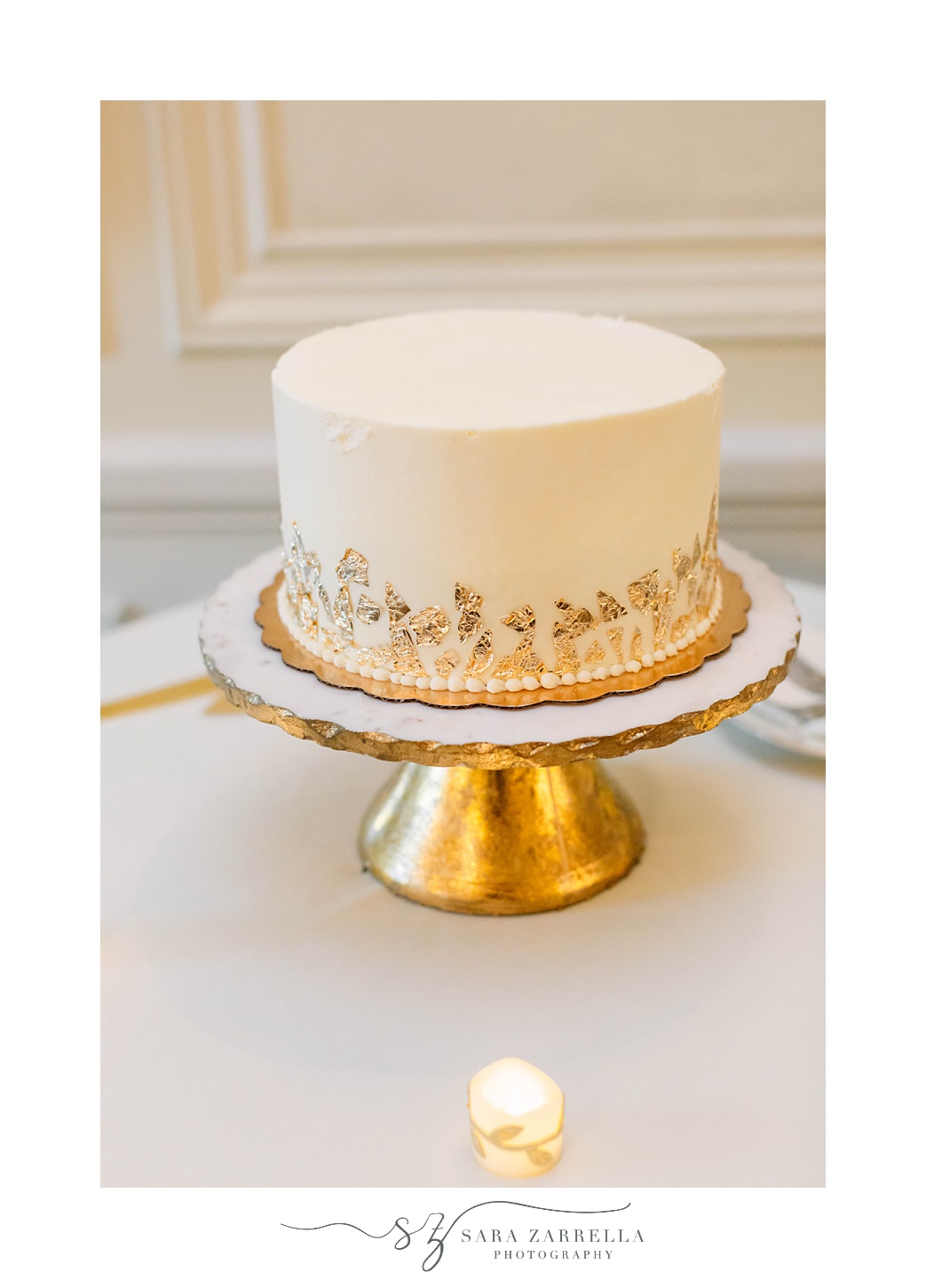 wedding cake on gold stand with gold edging 