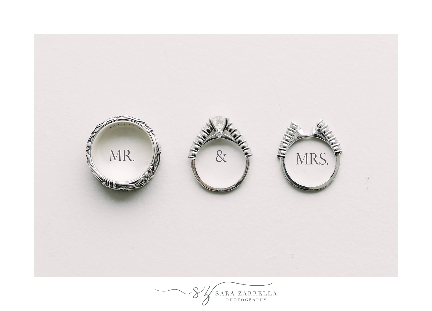 wedding bands sit with "mr & Mrs" underneath 