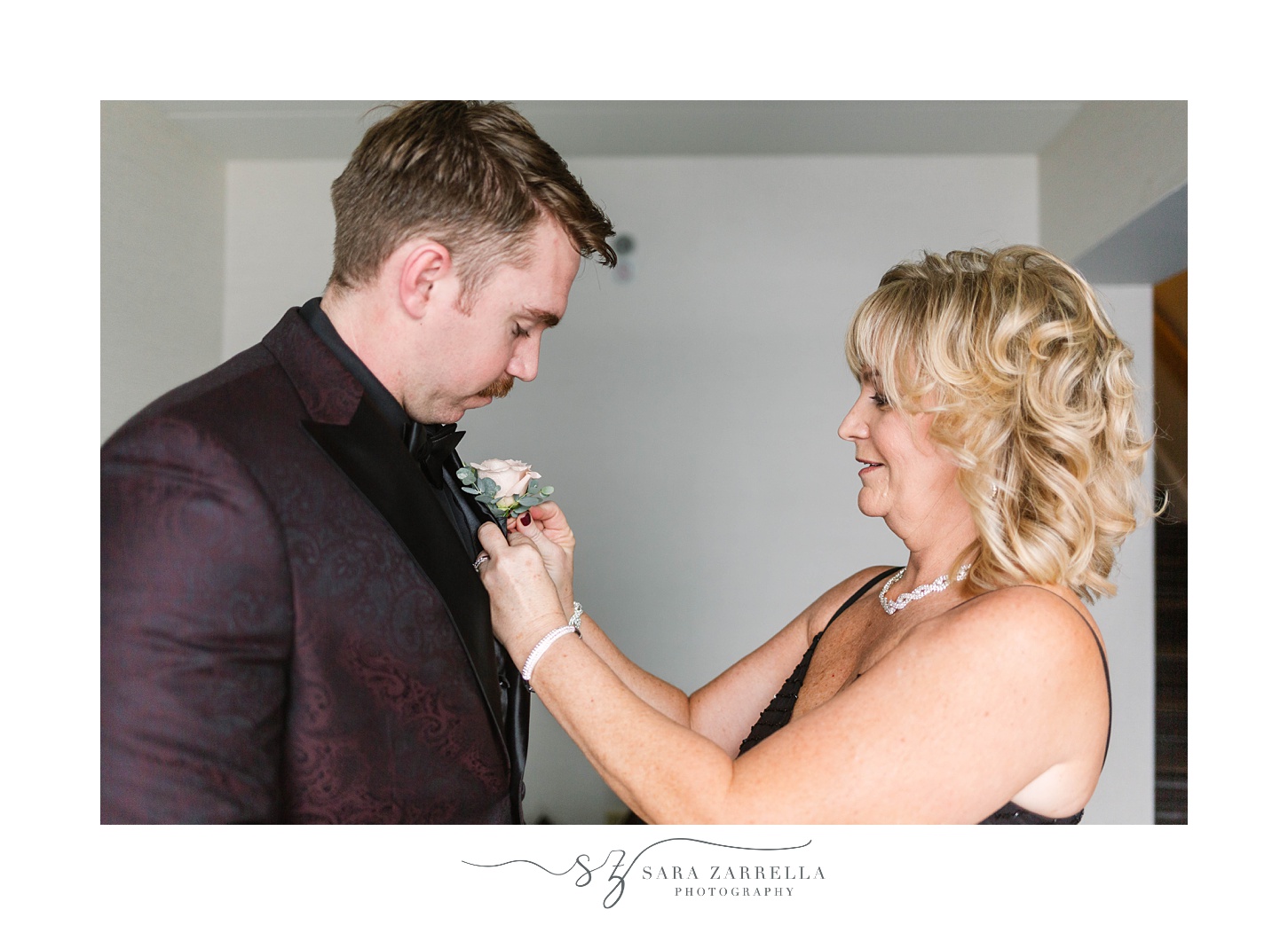 mother pins on boutonniere for winter wedding