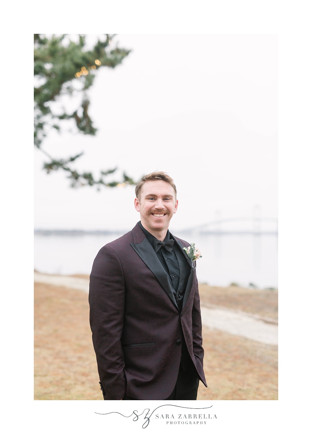 groom stands outside in burgundy jacket before NYE wedding