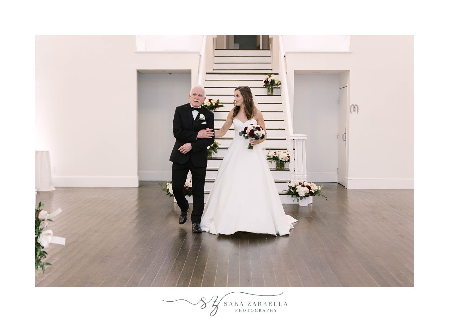bride and dad walk down staircase at Belle Mer