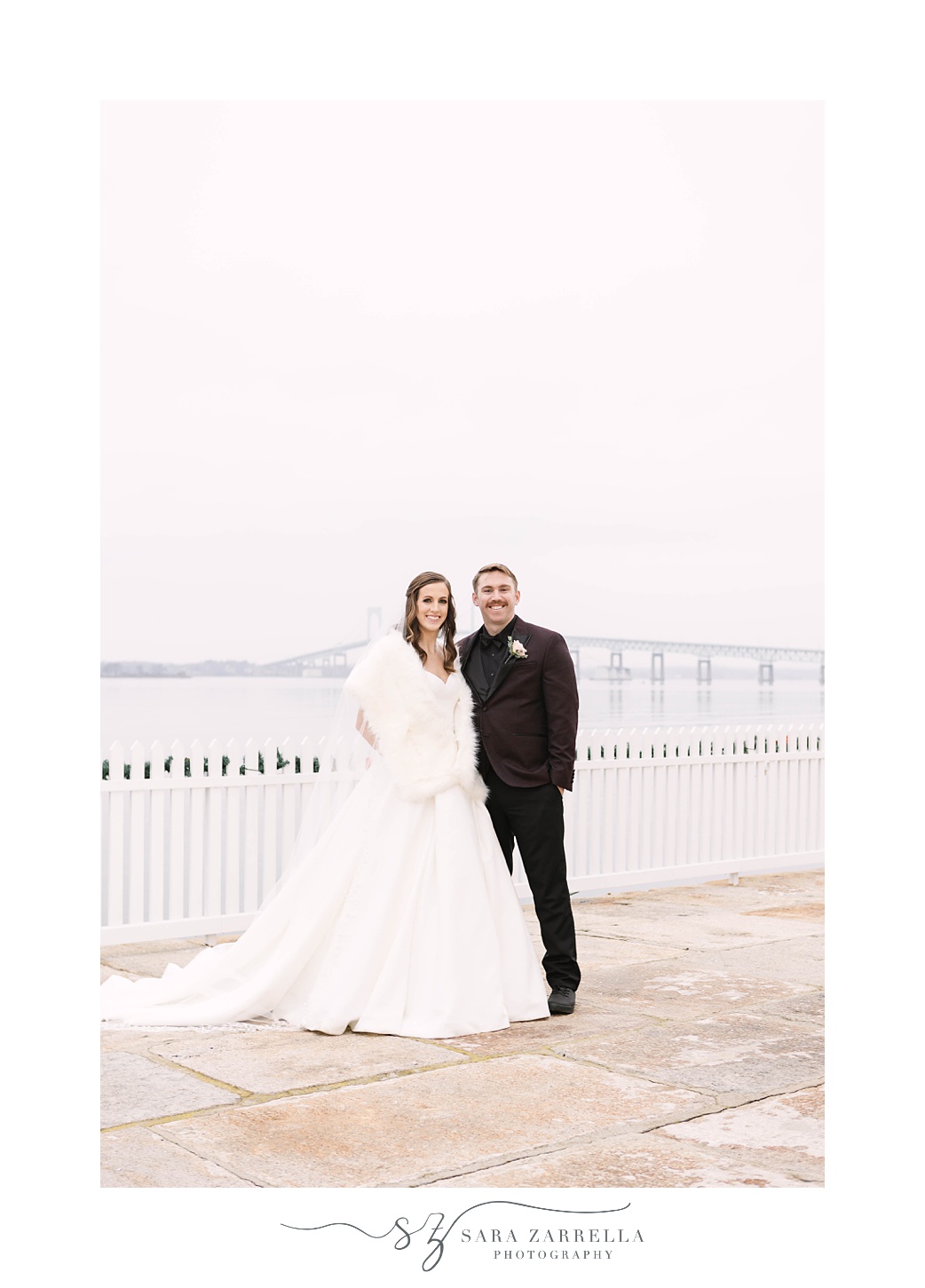 couple stands by bridge on Newport RI 