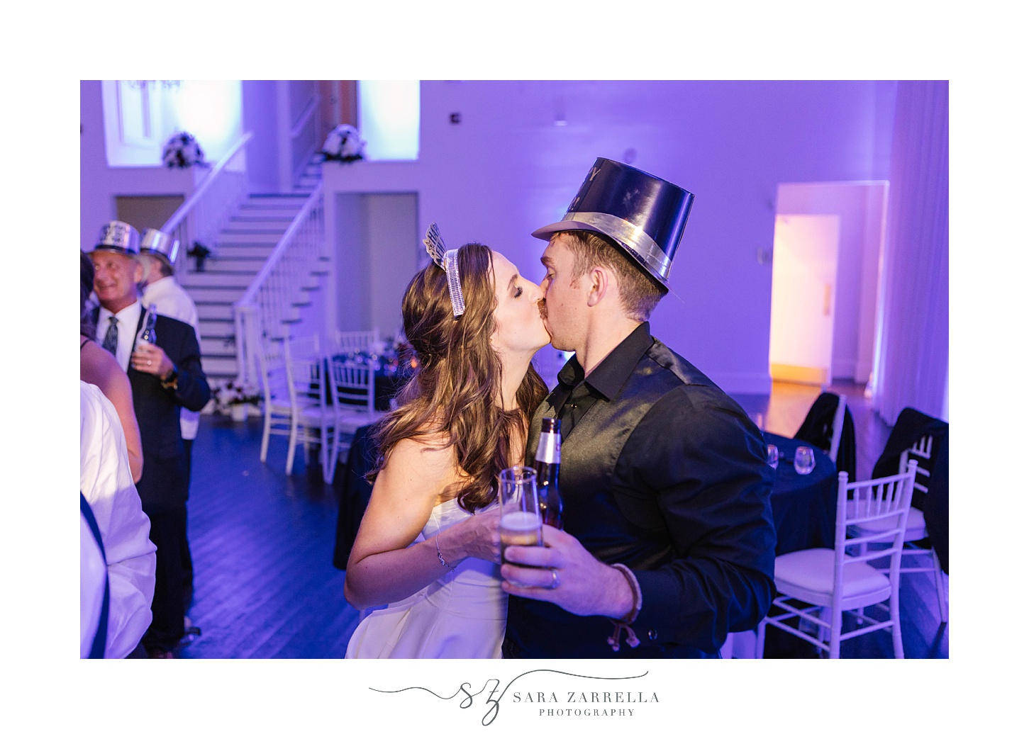 newlyweds kiss in party hats during New Year’s Eve Belle Mer wedding reception