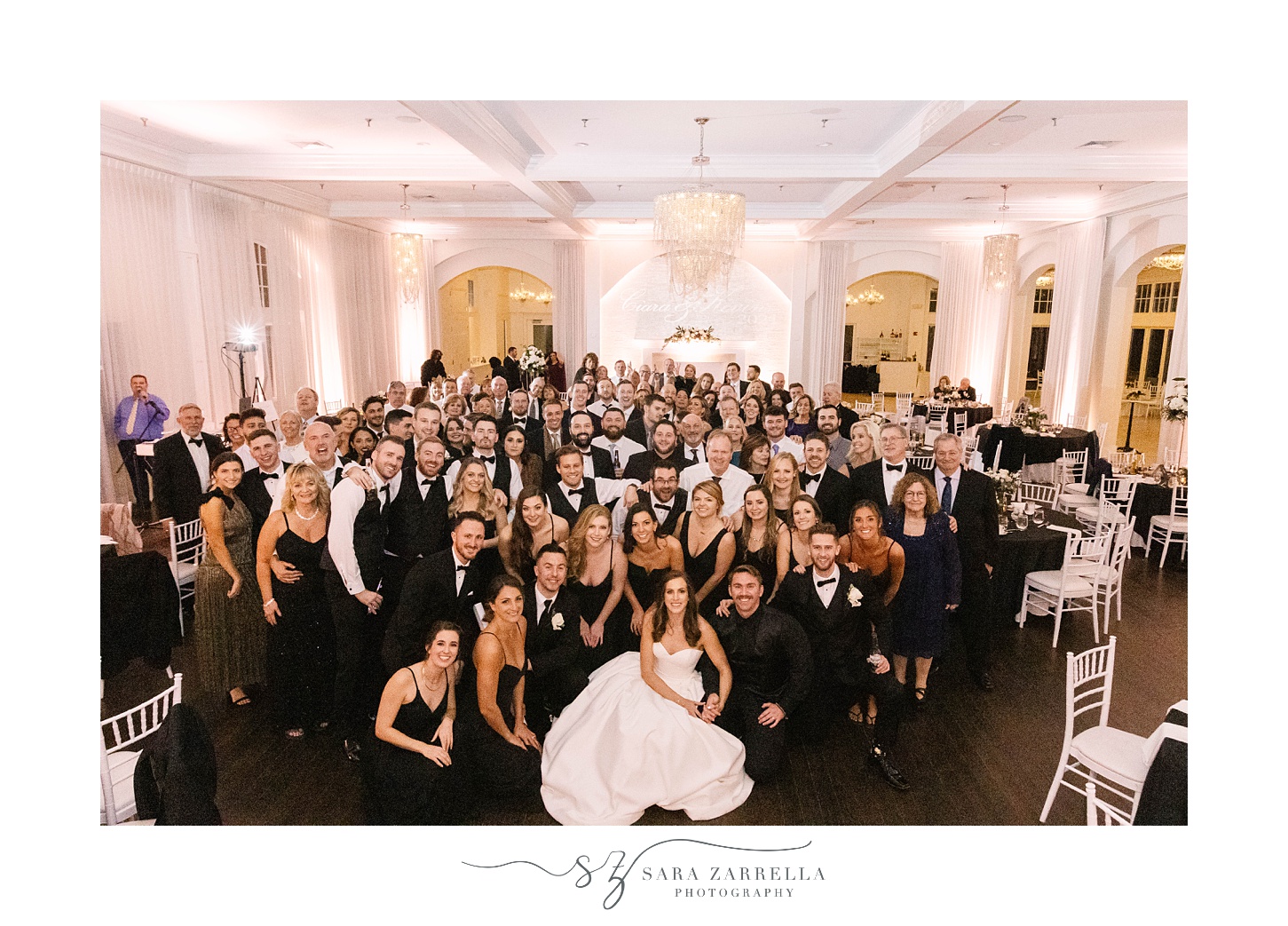 bride and groom pose with entire group of guests 