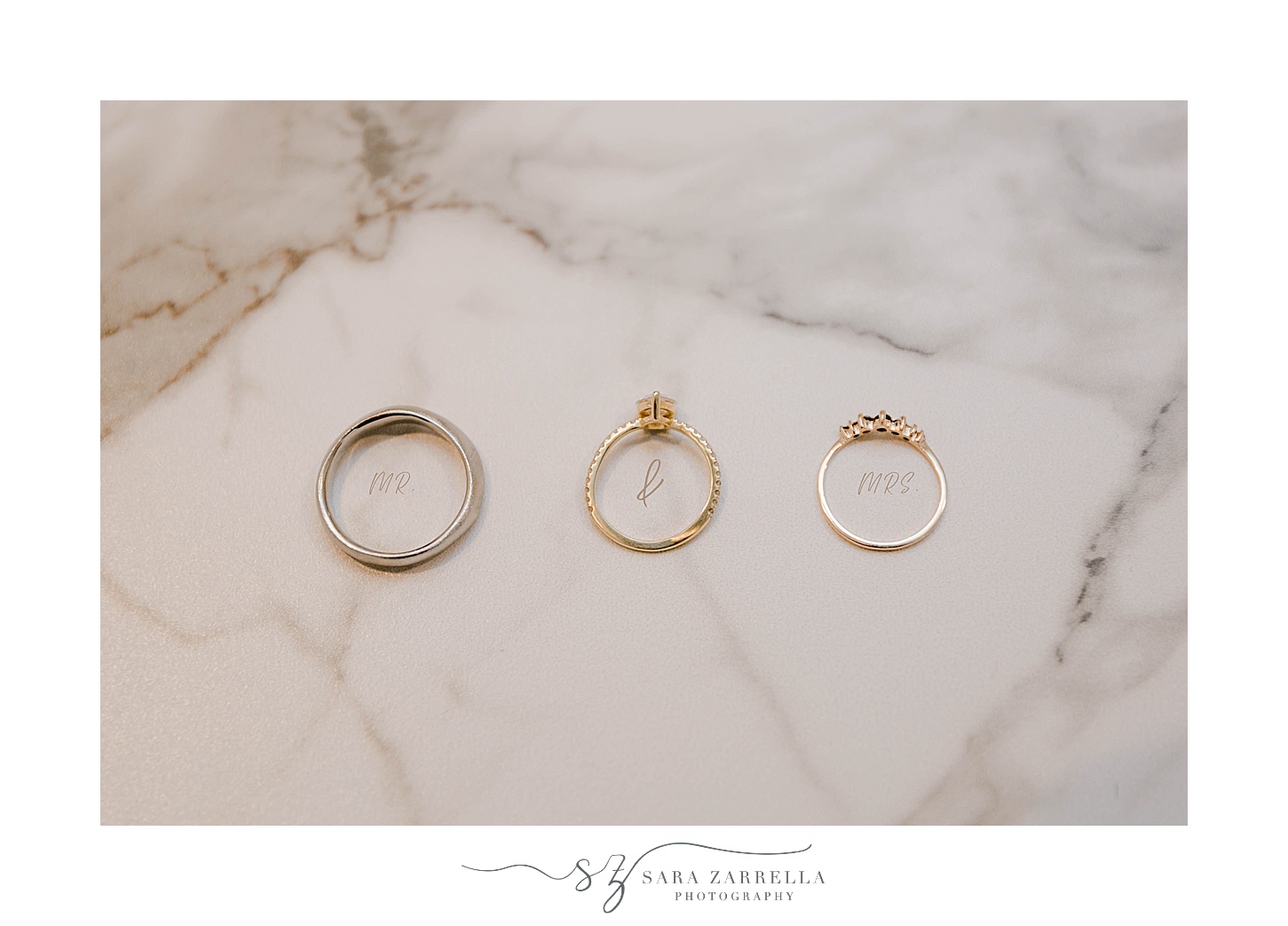 gold wedding bands lay on marble countertop