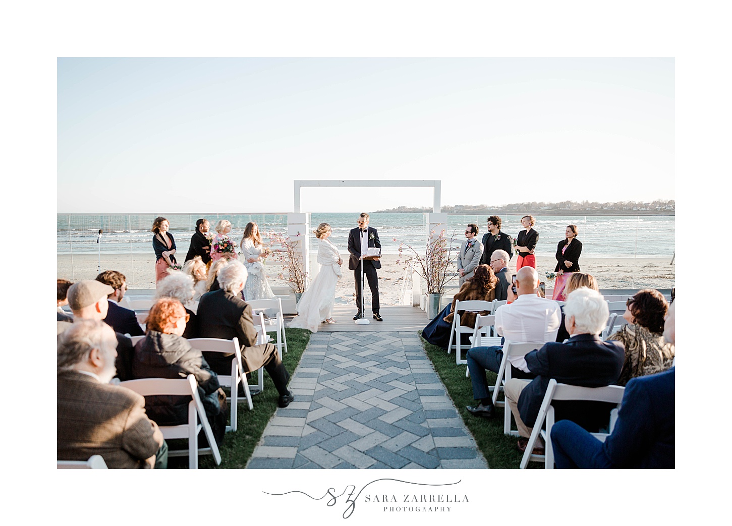 groom reads vows to bride during waterfront wedding ceremony