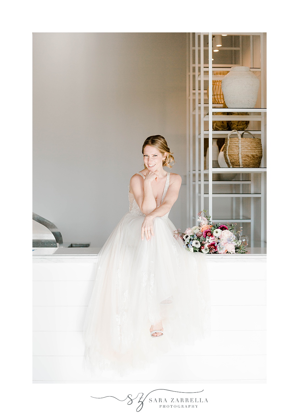 bride sits on white wall at Newport Beach House