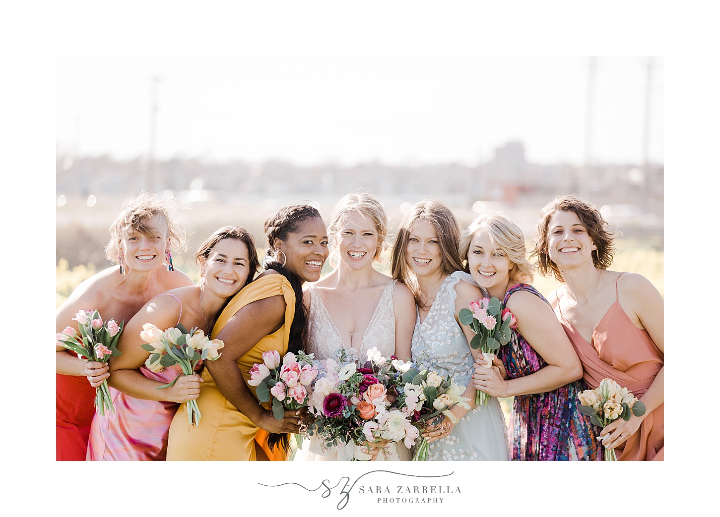 bride laughs with bridesmaids in mismatched gowns