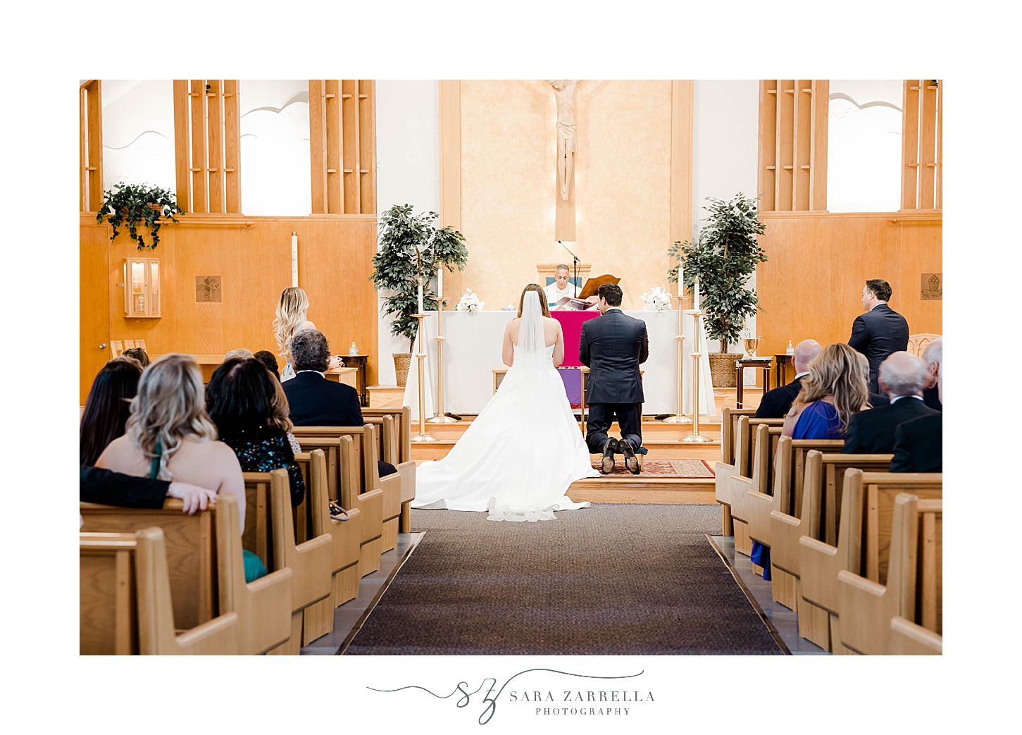 bride and groom kneel during traditional church wedding in South Kingstown RI