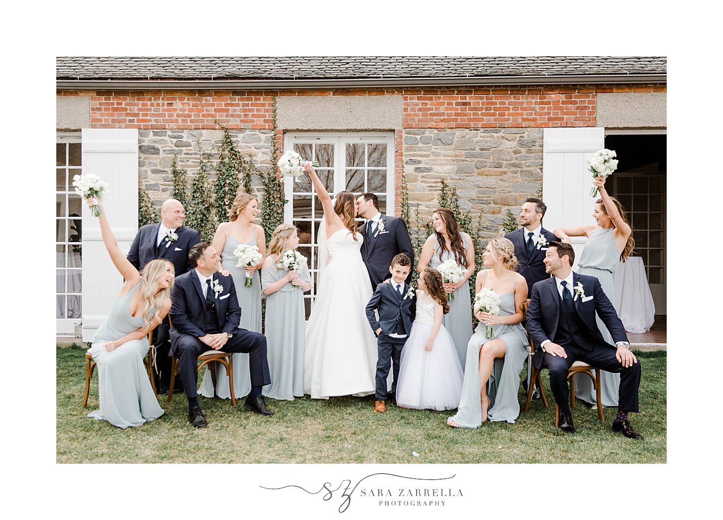 bridal party cheers while newlyweds kiss