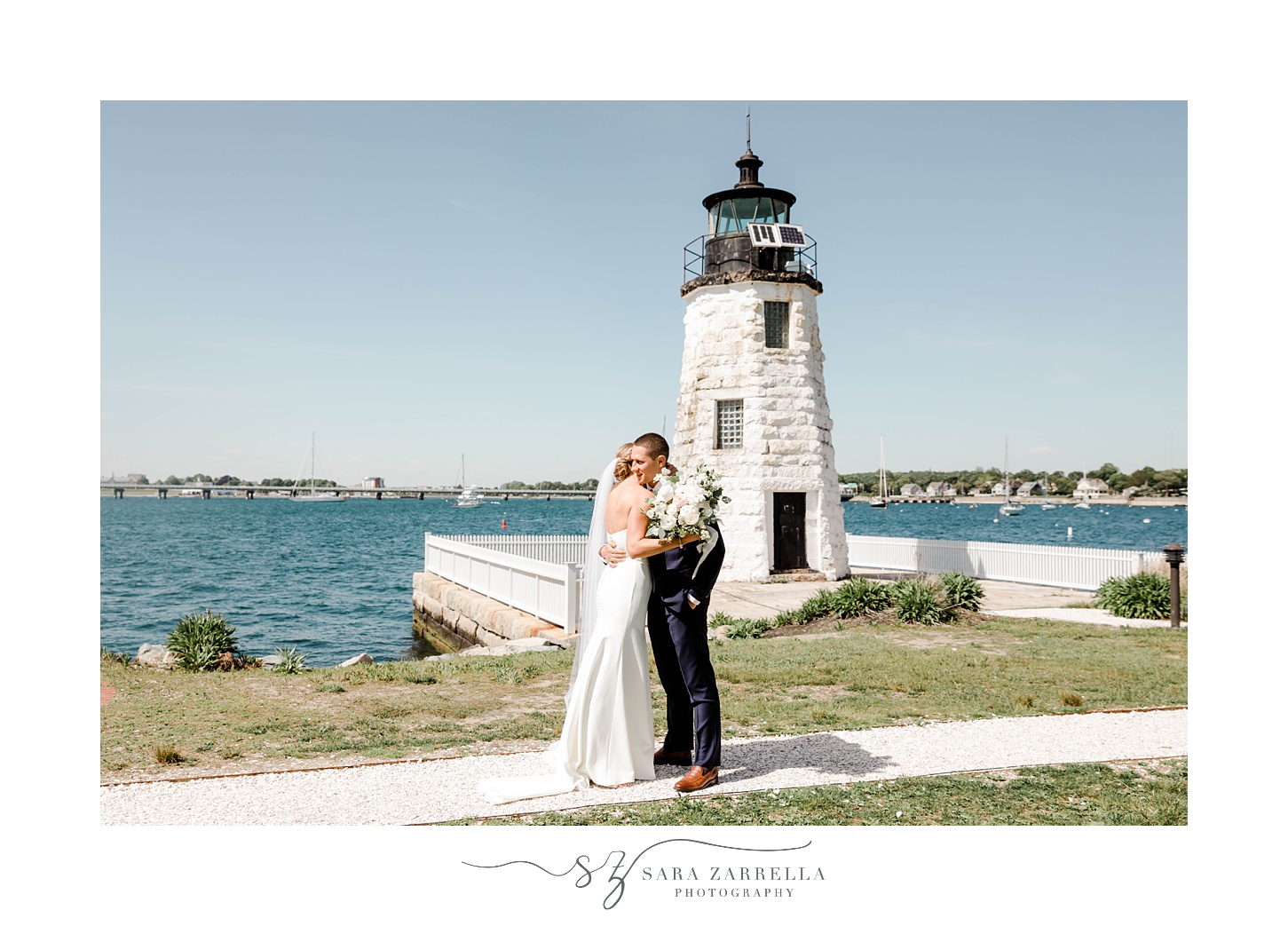 bride and groom hug by Newport lighthouse 