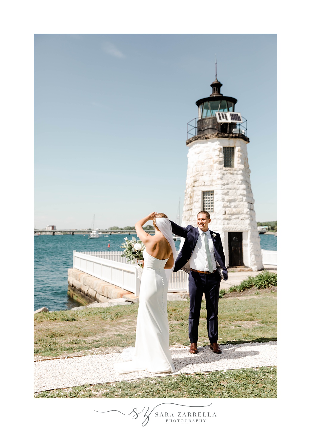 groom twirls bride by Newport Lighthouse at Gurney's Resort