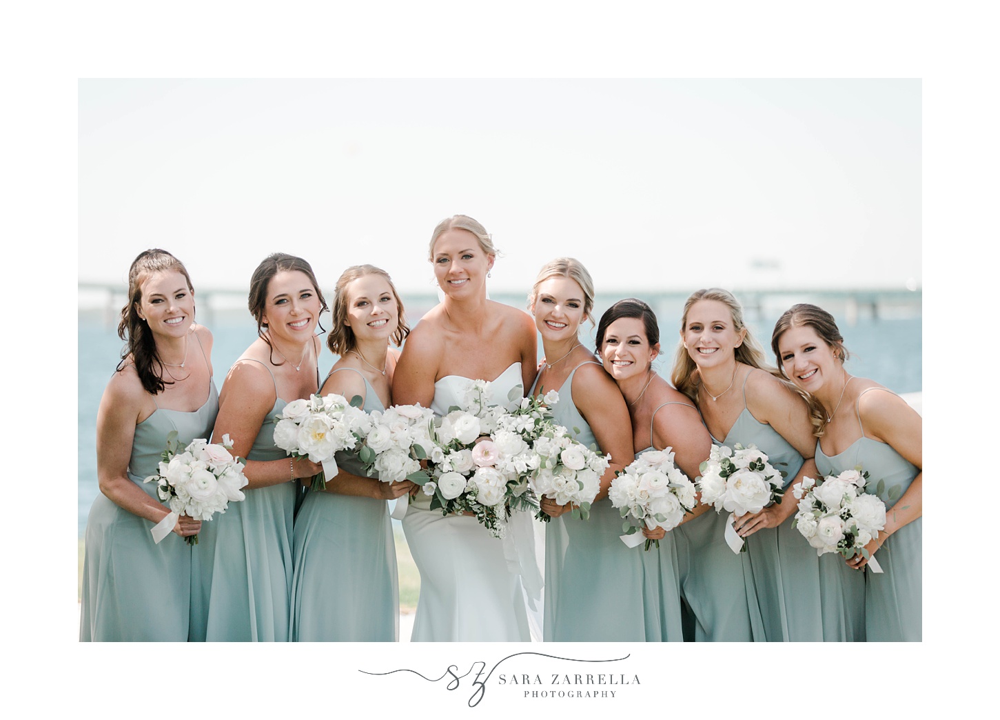bride smiles with bridesmaids holding white bouquets at Gurney's Resort