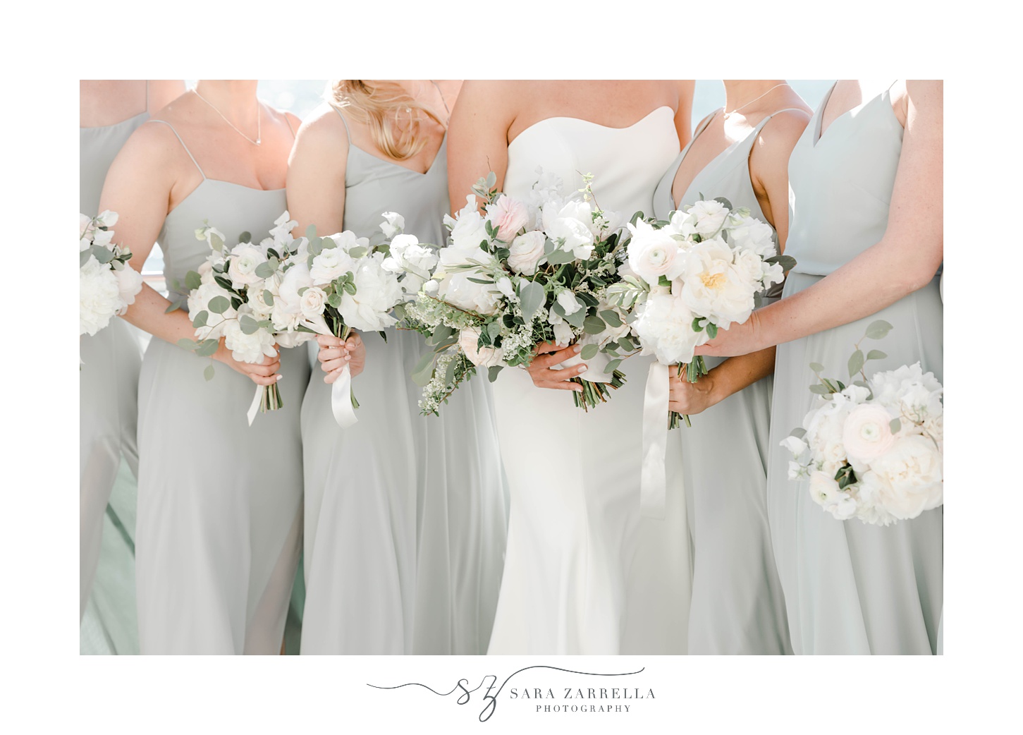 bride and bridesmaids in pale green gowns hold white bouquets 