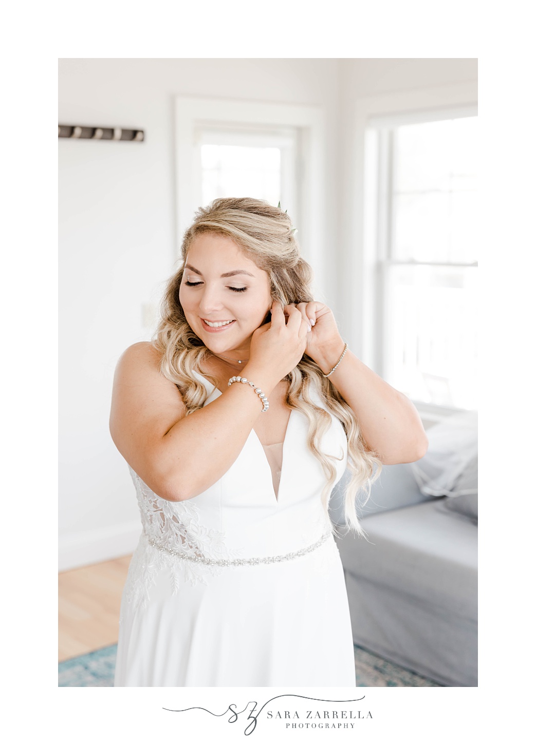 bride adjusts earrings before Rhode Island wedding 