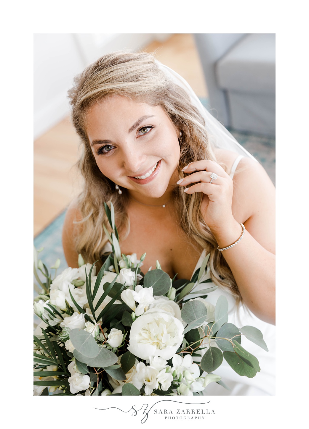 bride smiles up with hand against chin holding bouquet 