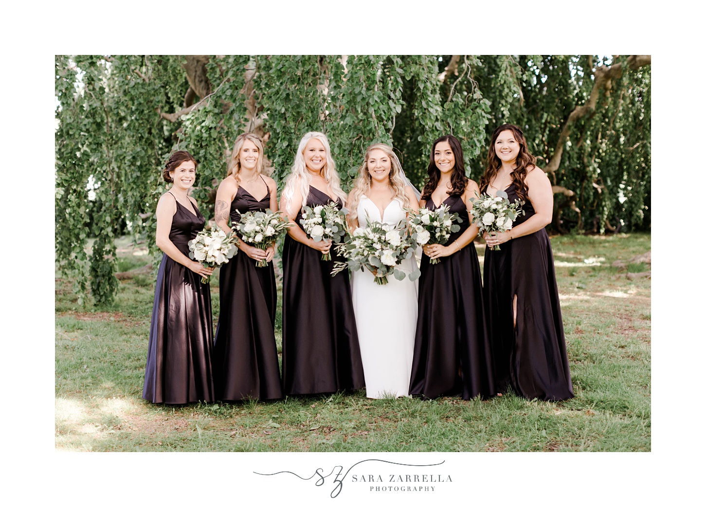 bride stands with bridesmaids in black gowns at The Elms