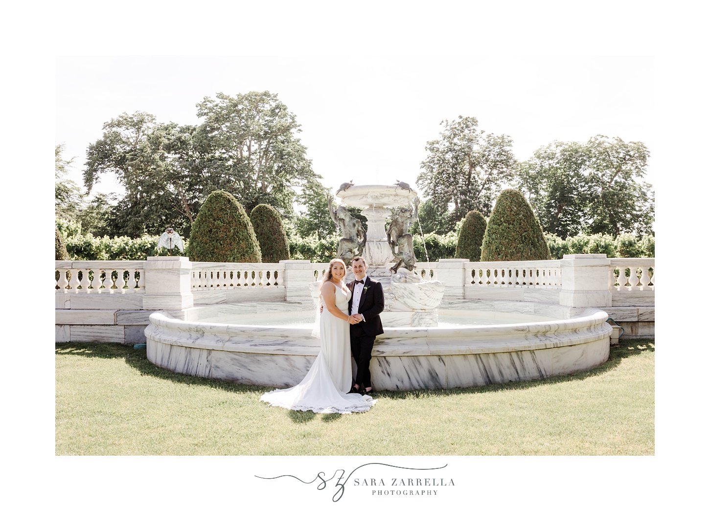 newlyweds smile by stone fountain at The Elms