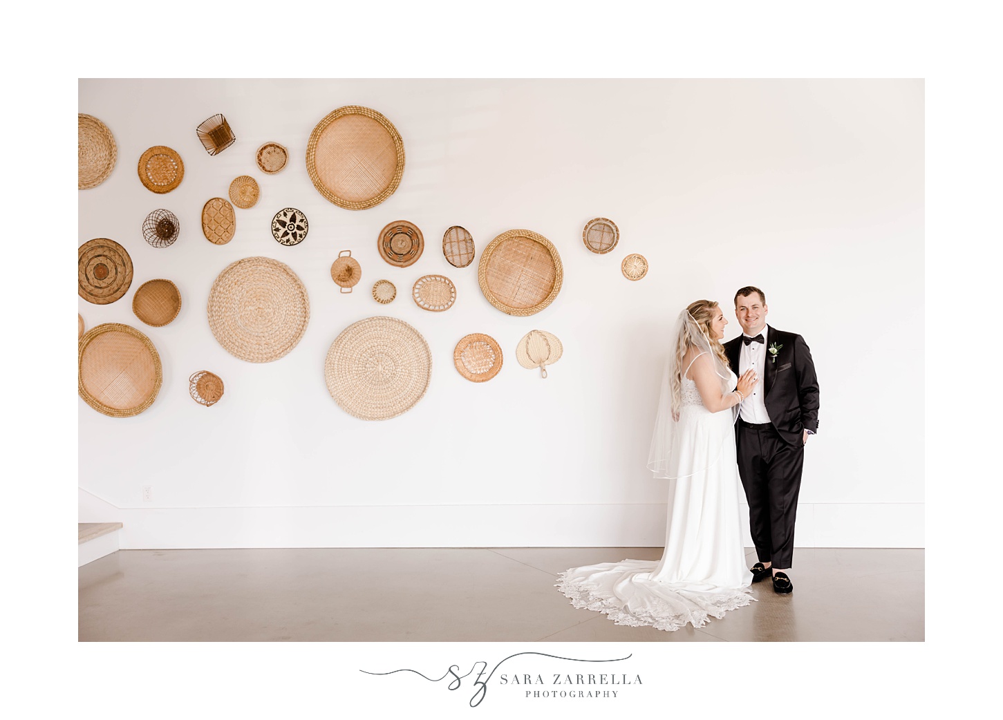 newlyweds pose on wall with baskets hanging in Newport Beach House