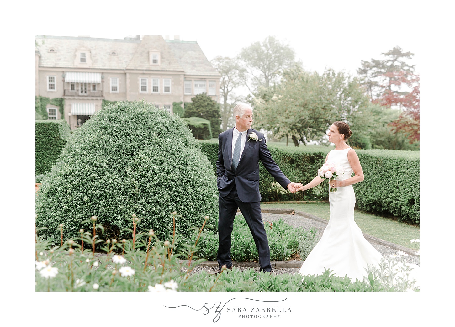 bride and groom hold hands walking through gardens at The Chanler