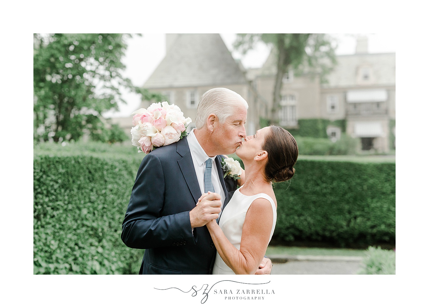 bride and groom kiss while bride's pink bouquet is behind groom's head