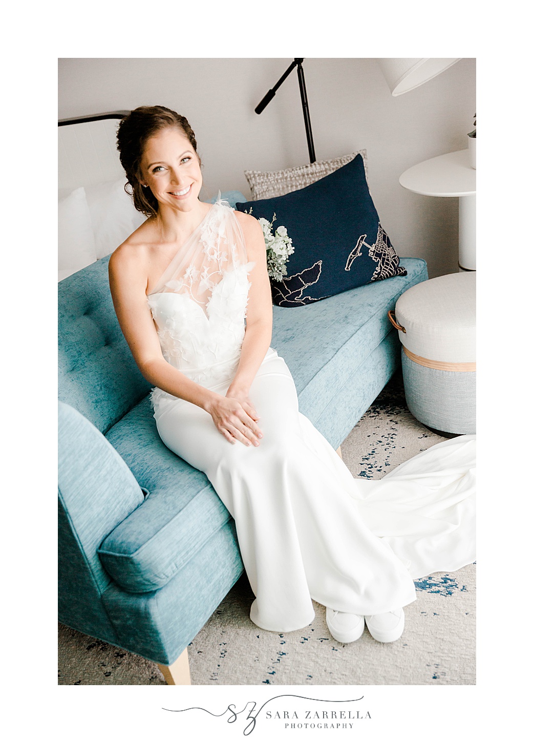 bride sits on blue couch preparing for RI wedding day