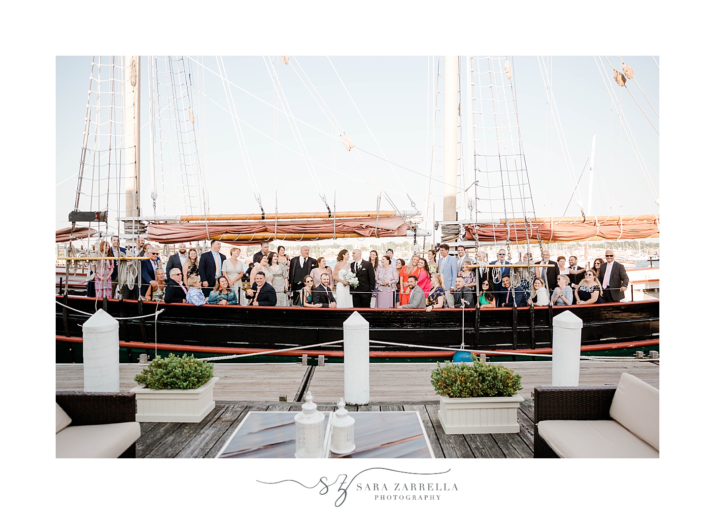 bride and groom stand with guests on schooner Aurora