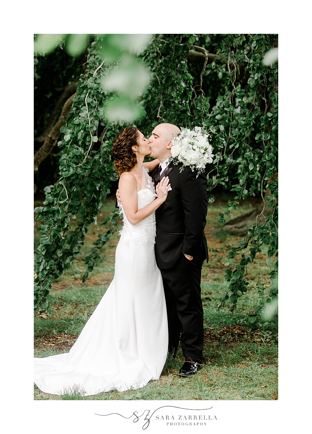 newlyweds kiss under tree at The Elms in Newport RI
