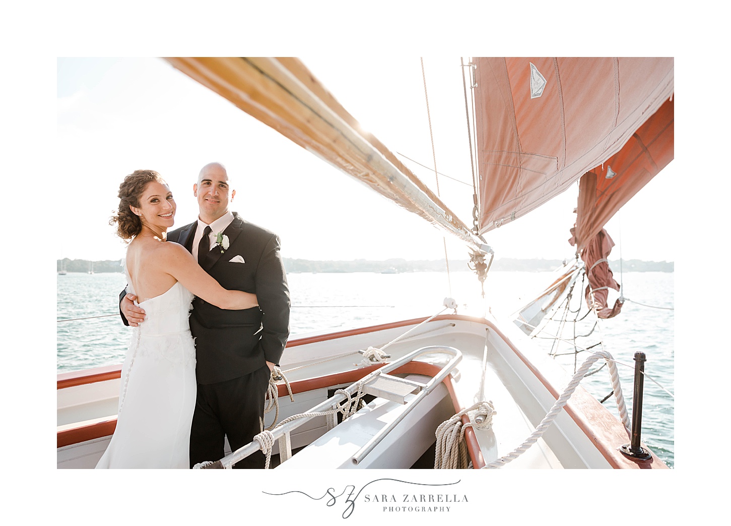 newlyweds laugh standing together on the Schooner Aurora