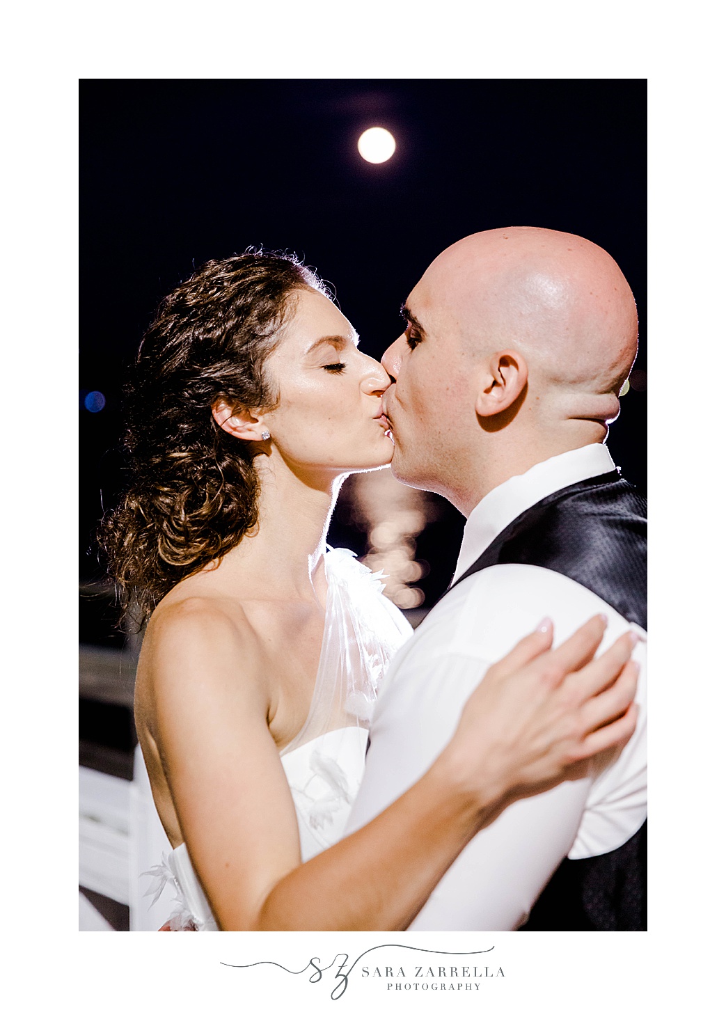 newlyweds kiss during nighttime wedding portraits in Newport RI